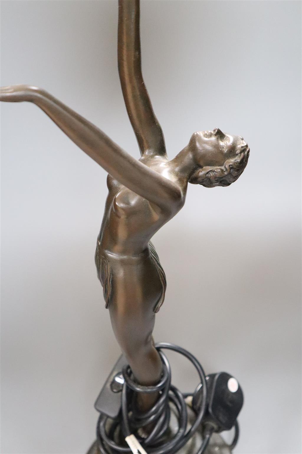 An Art Deco style bronzed resin figural table lamp, semi-nude female holding glass shade aloft, 66cm overall